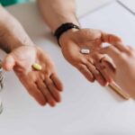Doctor giving two different pills to randomized treatment client in clinic
