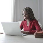 Woman smiling at laptop after batch edit checks have been applied