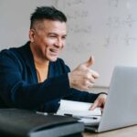 Man giving thumbs up to laptop during UAT testing