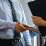 Two people shaking hands to celebrate Canela Capital acquisition