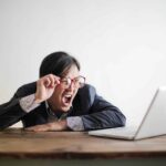 Man yelling at laptop due to data entry mistakes